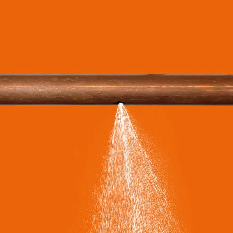 leak in copper pipe on orange background